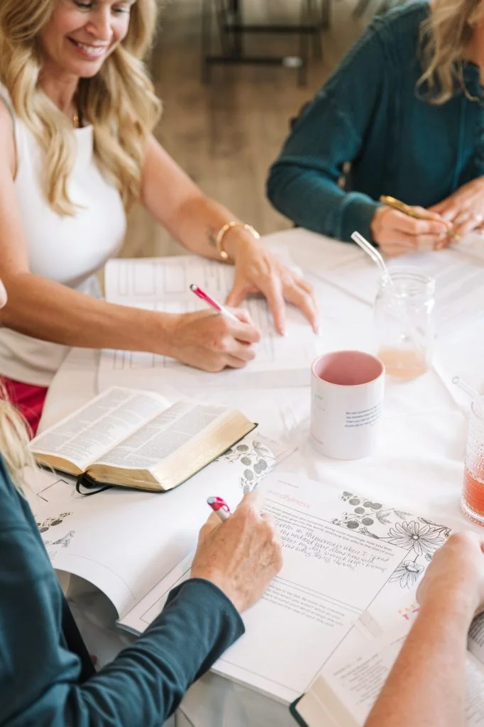 Women journaling with their Bibles at a Fast to Faith gathering